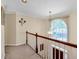 Upstairs hallway with staircase and hanging pendant light at 222 Mossy Pl, Alpharetta, GA 30005