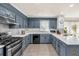 Well-lit kitchen featuring stainless steel appliances, granite countertops, and ample cabinet space at 222 Mossy Pl, Alpharetta, GA 30005