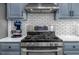Close-up of stainless steel oven and cooktop with granite countertops and blue mixer at 222 Mossy Pl, Alpharetta, GA 30005