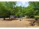 Community playground featuring colorful play structures, swings, and seating in a wooded setting at 222 Mossy Pl, Alpharetta, GA 30005