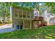 This house features a sunroom above a covered patio and wooden deck with stairs to the backyard at 222 Mossy Pl, Alpharetta, GA 30005