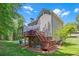 An angled view of the home's back exterior, featuring a deck with stairs and backyard at 222 Mossy Pl, Alpharetta, GA 30005