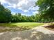 Expansive recreation field with lush grass, playground, and treeline, perfect for various outdoor activities at 222 Mossy Pl, Alpharetta, GA 30005