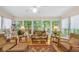 Bright sunroom features hardwood floors, lots of windows and wicker furniture at 222 Mossy Pl, Alpharetta, GA 30005