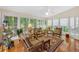 Bright sunroom features hardwood floors, lots of windows and wicker furniture at 222 Mossy Pl, Alpharetta, GA 30005