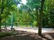 Scenic sand volleyball court surrounded by mature trees and convenient seating for a relaxing outdoor activity at 222 Mossy Pl, Alpharetta, GA 30005