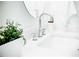 Chrome bathroom sink with white counters, a round mirror and greenery at 2276 Sutton Se St, Atlanta, GA 30317