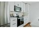 Kitchen with stainless steel appliances, white cabinets, herringbone backsplash, and modern fixtures at 2276 Sutton Se St, Atlanta, GA 30317