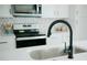 Close-up of kitchen sink and faucet with white countertops, stainless steel sink and appliances at 2276 Sutton Se St, Atlanta, GA 30317
