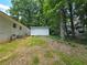 View of home's backyard with a storage building surrounded by mature trees at 345 Forest Valley Rd, Lawrenceville, GA 30046