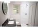 Modern bathroom featuring updated sink, stylish mirror, and a shower stall with white tiled walls at 345 Forest Valley Rd, Lawrenceville, GA 30046