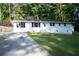 Charming front yard with mature trees and long driveway leading to a white brick home at 345 Forest Valley Rd, Lawrenceville, GA 30046