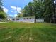 This brick home is nestled among the trees with a verdant front yard and storage building at 345 Forest Valley Rd, Lawrenceville, GA 30046