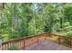 Wooden deck with wooded view offers a serene outdoor living space surrounded by lush trees and foliage at 3741 Windhurst Dr, Lilburn, GA 30047