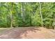 View of the wooded backyard, with a retaining wall feature at the top of a small slope at 3741 Windhurst Dr, Lilburn, GA 30047