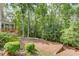 View of the wooded backyard with adjacent screened porch and patio at 3741 Windhurst Dr, Lilburn, GA 30047