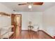 Neutral bedroom featuring wood floors and a chair, with a peek into the en suite bathroom at 3741 Windhurst Dr, Lilburn, GA 30047