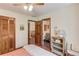 Bedroom featuring wood doors, warm tones, wood floors, and access to a bathroom and hallway at 3741 Windhurst Dr, Lilburn, GA 30047