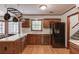 The kitchen features wooden cabinets, a black refrigerator, and a view into the dining area at 3741 Windhurst Dr, Lilburn, GA 30047