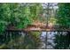 Scenic lake view with a private dock and staircase for easy access to the water, nestled amongst mature trees at 3741 Windhurst Dr, Lilburn, GA 30047
