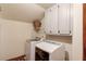 Laundry room featuring white cabinets, modern washer and dryer units, and laminate wood flooring at 3741 Windhurst Dr, Lilburn, GA 30047