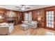 Cozy living room with a fireplace, built-in shelving, wood paneling, and access to the outdoors at 3741 Windhurst Dr, Lilburn, GA 30047