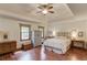 Spacious main bedroom with tray ceiling, ceiling fan, and wood floors at 3741 Windhurst Dr, Lilburn, GA 30047