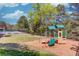 Community playground with modern play structure, picnic tables, and views of adjacent community pool and trees at 3741 Windhurst Dr, Lilburn, GA 30047