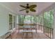 Relaxing screened porch with ceiling fan, wooden furniture, and peaceful view of the surrounding greenery at 3741 Windhurst Dr, Lilburn, GA 30047