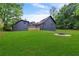 Large backyard with green grass, deck, and a stone fire pit area at 4131 West Village Pkwy, Ellenwood, GA 30294