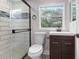 Bathroom with tiled shower, window, and dark wood vanity at 4131 West Village Pkwy, Ellenwood, GA 30294