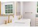 A bathroom with double sink, gold fixtures and a rectangular mirror above each sink at 4131 West Village Pkwy, Ellenwood, GA 30294