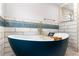 A bathtub with blue accent tiling, gold fixtures and white tiling at 4131 West Village Pkwy, Ellenwood, GA 30294