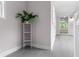 Light-filled hallway with light gray flooring and accent plant at 4131 West Village Pkwy, Ellenwood, GA 30294
