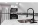 Modern kitchen with stainless steel appliances, double sink, and herringbone backsplash at 4131 West Village Pkwy, Ellenwood, GA 30294