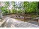 Expansive wooden deck looks out onto a wooded area, framed by a retaining wall and decorative flower boxes at 7240 Highbrook Cir, Cumming, GA 30041