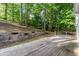 Spacious wooden deck with retaining wall and flower boxes overlooks a lush, wooded backyard at 7240 Highbrook Cir, Cumming, GA 30041