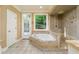Bright bathroom with a walk-in shower, tile floors, and a soaking tub at 7240 Highbrook Cir, Cumming, GA 30041