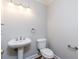 Chic half-bathroom boasts a pedestal sink, toilet, and modern fixtures at 7240 Highbrook Cir, Cumming, GA 30041