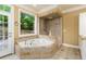 Bright bathroom with a walk-in shower, tile floors, and a soaking tub at 7240 Highbrook Cir, Cumming, GA 30041