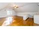 Bright bonus room featuring wood floors, a ceiling fan, and wet bar at 7240 Highbrook Cir, Cumming, GA 30041