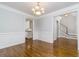 Formal dining room with detailed trim, hardwood floors, and view to staircase and kitchen at 7240 Highbrook Cir, Cumming, GA 30041