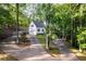 Charming two-story home with a manicured yard and a long driveway through a wooded area at 7240 Highbrook Cir, Cumming, GA 30041
