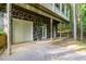 A stone-clad, multi-car garage is underneath a two-story house with a porch above at 7240 Highbrook Cir, Cumming, GA 30041