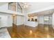 Open-concept living room with hardwood floors, a kitchen view, and a high ceiling at 7240 Highbrook Cir, Cumming, GA 30041