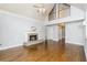 Open-concept living room with hardwood floors, a fireplace, and a high ceiling at 7240 Highbrook Cir, Cumming, GA 30041