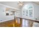 Bright living room with hardwood floors, a kitchen view, and a large window at 7240 Highbrook Cir, Cumming, GA 30041