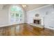 Bright living room with hardwood floors, a fireplace, and a large window at 7240 Highbrook Cir, Cumming, GA 30041