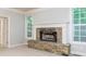 Bright living room featuring a stone fireplace and large windows at 7240 Highbrook Cir, Cumming, GA 30041