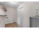 Functional laundry room with shelving, tile floor, and essential hookups at 10116 Straphinge Trl, Covington, GA 30014